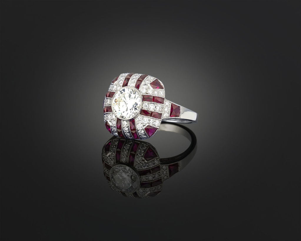 Elegance is beautifully reflected in this ruby and diamond platinum ring. Rubies totaling 3.25 carats radiate from a central white diamond, weighing 1.29 carats, while .40 carats of diamond accents provide additional shimmer.

Size 7 1/2