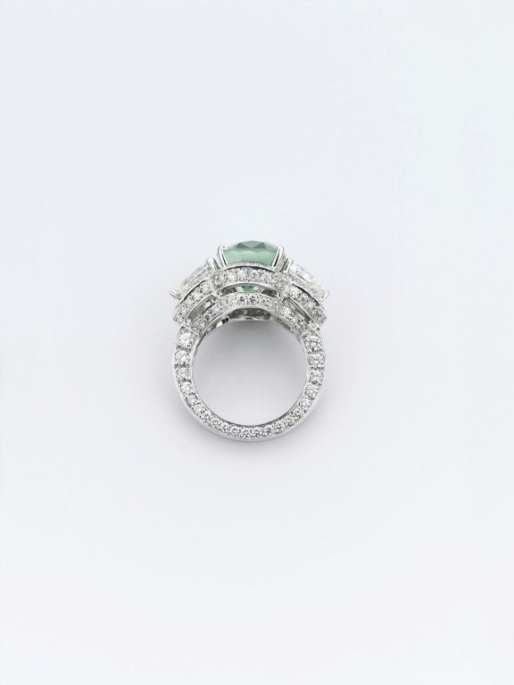 An extremely rare and absolutely stunning Burmese green sapphire takes pride of place in this incredible ring. Weighing 10.26 carats, this cushion-cut, natural jewel exhibits a silky celadon hue and flashes with brilliance thanks to its exceptional