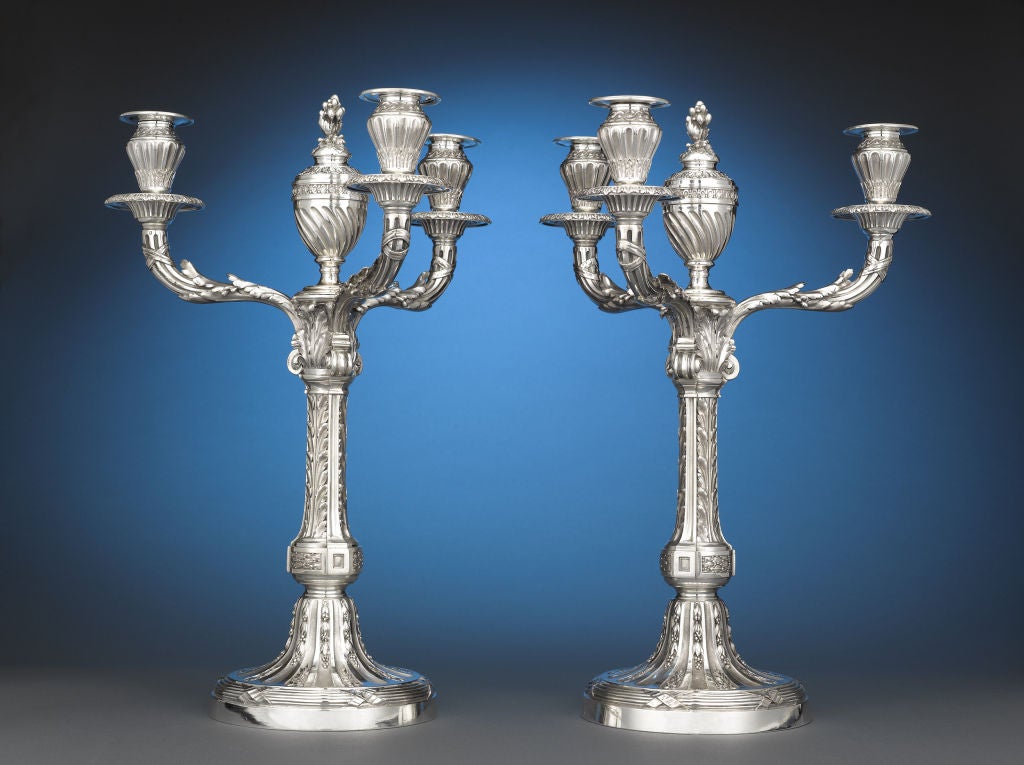 A splendid pair of French sterling silver candelabra, crafted by renowned silversmiths and jewelers Risler & Carré. The three-branched lights are exceptional examples of the Empire style, sumptuous yet classically inspired with lush acanthus and