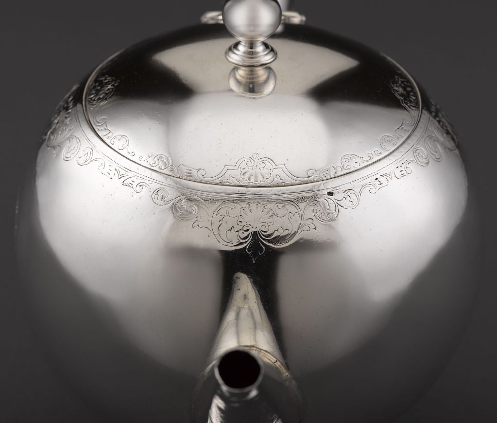 A rare and outstanding Scottish silver teapot by Edward Lothian. Crafted in an impressive bullet shape, this charming teapot features a dramatic, wood-insulated handle, subtle bright-cut engraving around the rim and hinged lid, and bears the