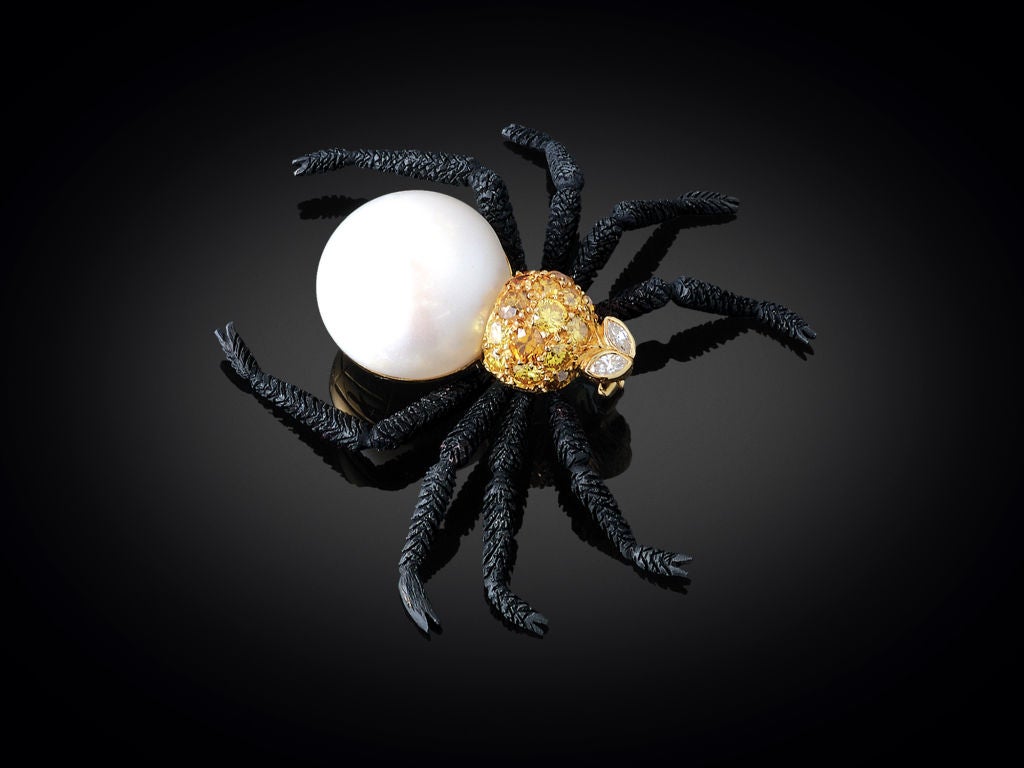 This whimsical spider brooch is amazing in its realism, set with a 17.30mm white pearl body and approximately 2.00 carats of colored and white diamonds. The detailed legs are crafted of 18K gold with a black rhodium finish, and the entire pin is set