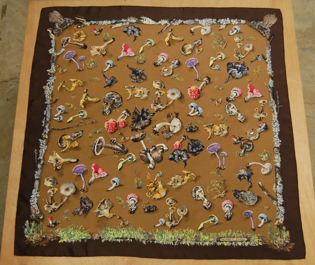 Here we have a 1959-issue 100% silk Hermes scarf entititled 'Champignons' by Anne Gavarni and Françoise De La Perriere. It is in the dark brown and bronze colorway and depicts various mushroom species framed by mossy brances. HERMES PARIS appears