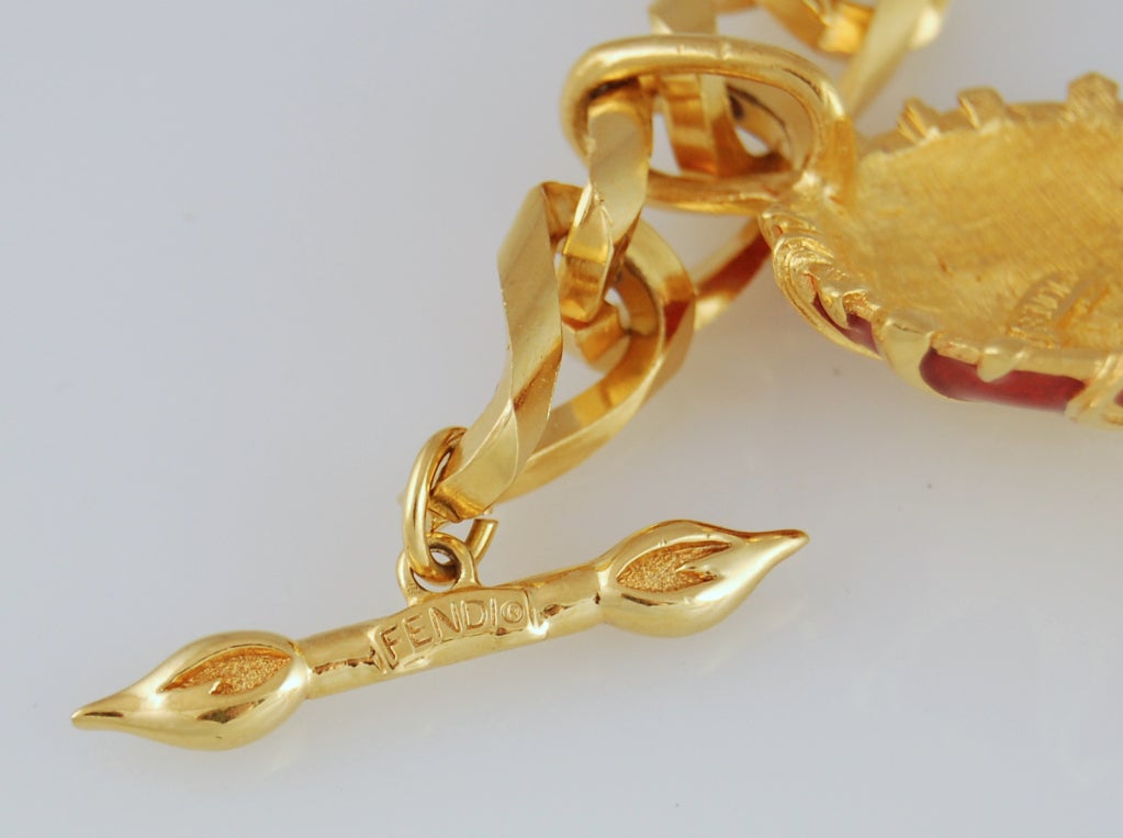 Here's a rare and exciting bracelet from Fendi. Large gold-tone chain bracelet with FENDI signed toggle clasp and a radiant, smiling sun charm with red enamel. Charm also signed Fendi on the reverse.

Charm measures 1 1/2