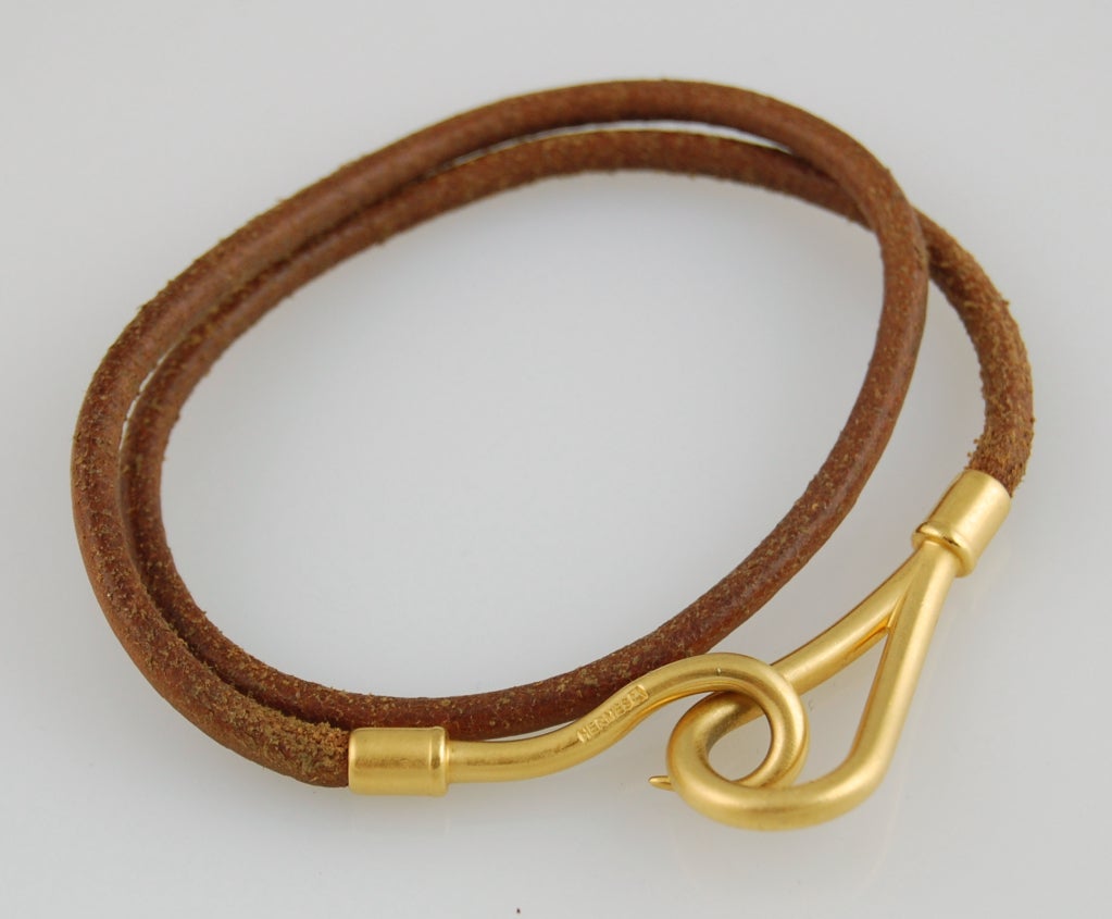 A lovely authentic Hermès bracelet in brown leather cord with brushed gold-tone hook closure. Can be worn as a bracelet or necklace. Add a touch of elegance to your casual look! 

Stamped Hermès