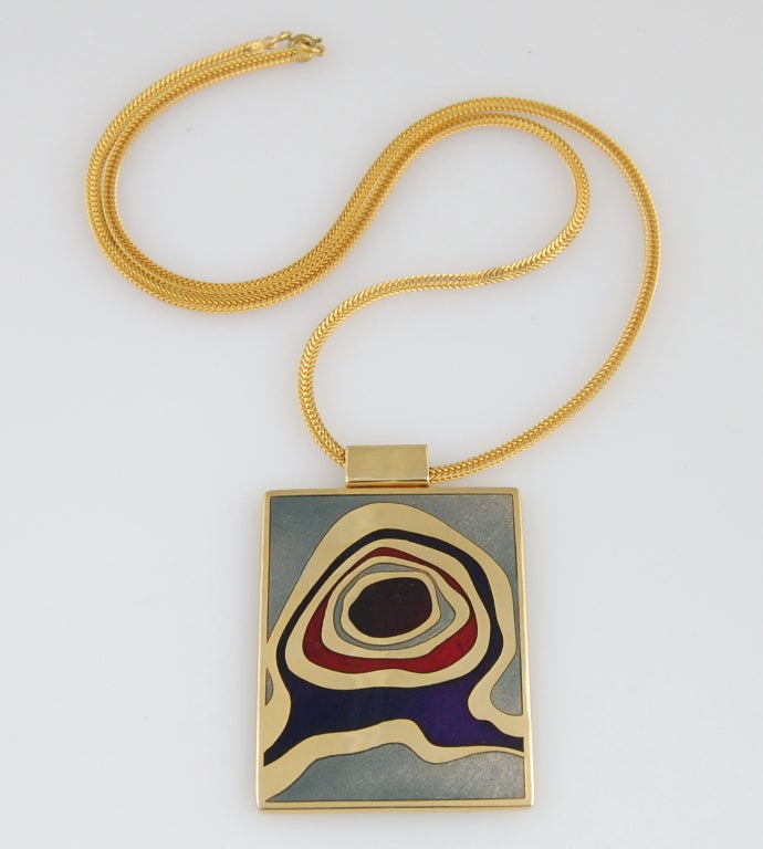 Gold plate enameled tablet necklace by Québécois jewelry design duo de Passile-Sylvestre featuring an abstract design in navy blue, red and gray.

