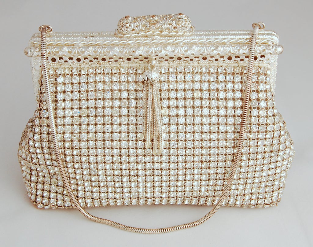 A dazzling vintage rhinestone bag! This bag has a stunningly ornate frame, a snake chain handle and is trimmed with a metal tassel.