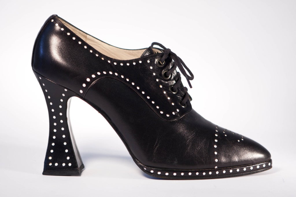 These black leather pumps are perforated to reveal white leather dots, creating a unique graphic effect! Fine vintage heels from the 90's with a flared heel, no doubt influenced by John Fluevog's iconic 'Munster'. These point-toed shoes elevate the