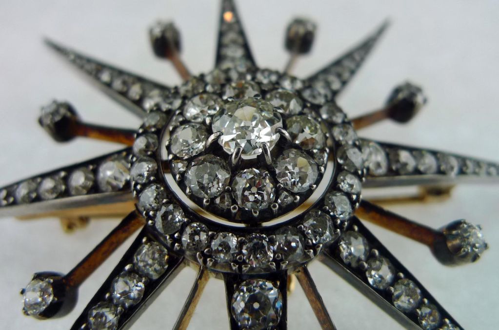 Important antique starburst brooch is hand constructed with original European cut diamonds throughout.  Central diamond is approximately 1 carat.  Total diamond weight is almost 8.5 carats. Piece can accomodate a chain as a pendant, or it can be