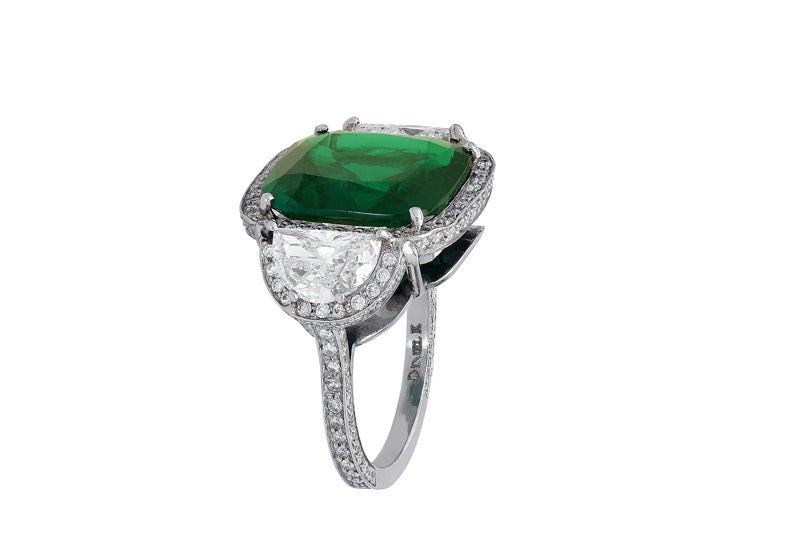 Platinum custom made 3 stone ring consisting of 1 cushion cut Colombian emerald weighing 7.14 carats, measuring 13.60 x 13.30 x 6.25mm with C. Dunaigre certificate CDC 1111200 stating intense green minor enhancement, the center stone if flanked by 2