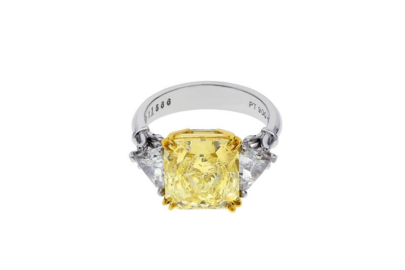Platinum and 18kt yellow gold and natural radiant cut canary diamond weighing 5.03 carats Fancy intense yellow/VS1 GIA Cert #11394525) flanked by 2 trilliant cut diamonds having a total weight of 1.10 carats.