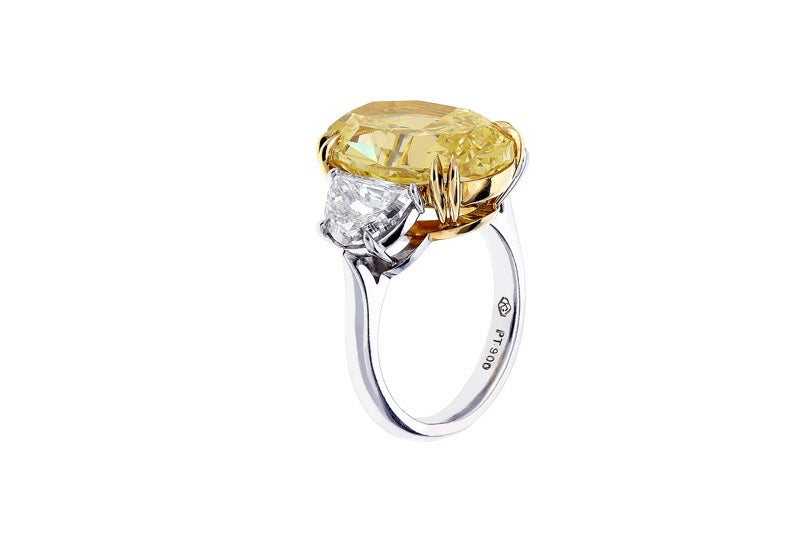 Platinum and 18 karat yellow gold 3 stone ring consisting of 1 oval shaped canary diamond weighing 8.16 carats having color and clarity of fancy yellow/SI1, measuring 15.22 x 10.54 x 6.62mm with GIA certificate #11394797, the center stone is flanked