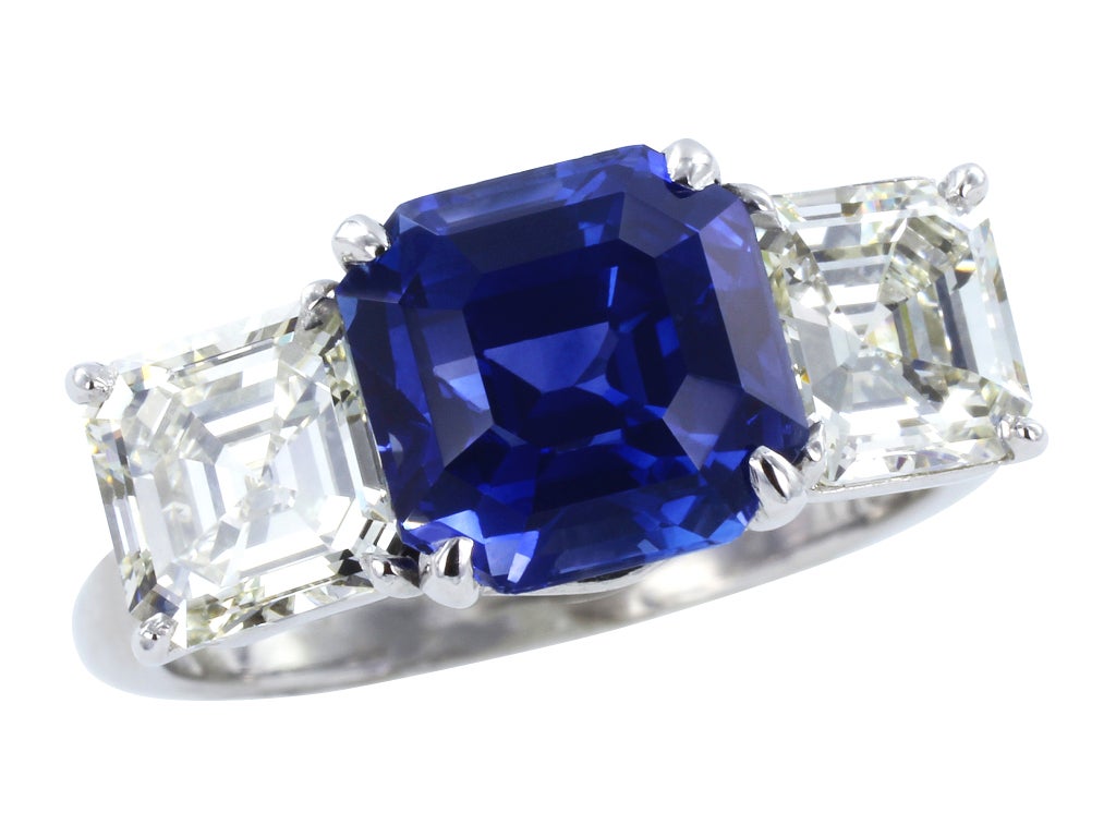 Platinum custom made 3 stone ring consisting of 1 asscher cut sapphire weighing 3.94 carats, measuring 8.38 x 8.26 x 6.24mm, the center stone is flanked by 2 asscher cut diamonds having a total weight of approximately 2.10 carats.