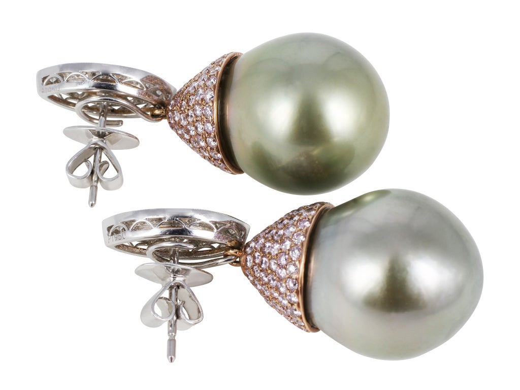 Two tone 18 karat white and pink gold drop earrings consisting of two Tahitian Greenish Gray approximately 17 x 18mm pearls set with 2.89 carats total weight of natural pink diamonds and .70 carats total weight of full cut colorless diamonds. The
