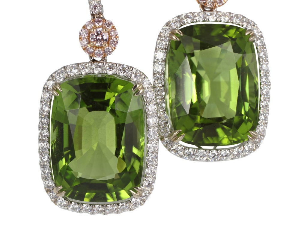 18 karat white gold drop earrings consisting of 2 cushion cut peridots having a total weight of 19.73 carat with CDC certificate #1205101/1&2 set with .31 carats total weight of pink diamonds and .72 carats total weight of colorless diamonds.