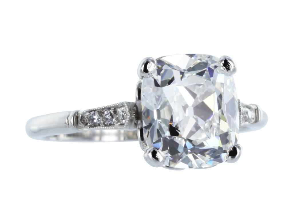 Platinum vintage style solitaire engagement ring consisting of 1 cushion cut diamond, weighing 2.40 carats, measuring 8.45 x 7.38 x 5.07 mm, having a color and clarity of G/VS2 and GIA report number 1142836594. The mounting is accented by 6 bead set