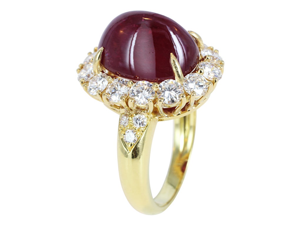 Estate Van Cleef and Arpels 18 karat yellow gold cluster ring consisting of 1 oval sugar loaf cabochon cut No Heat Thai ruby weighing 9.42 carats, with AGL report CS 53499. The center stone is surrounded with 14 round brilliant cut diamonds and a