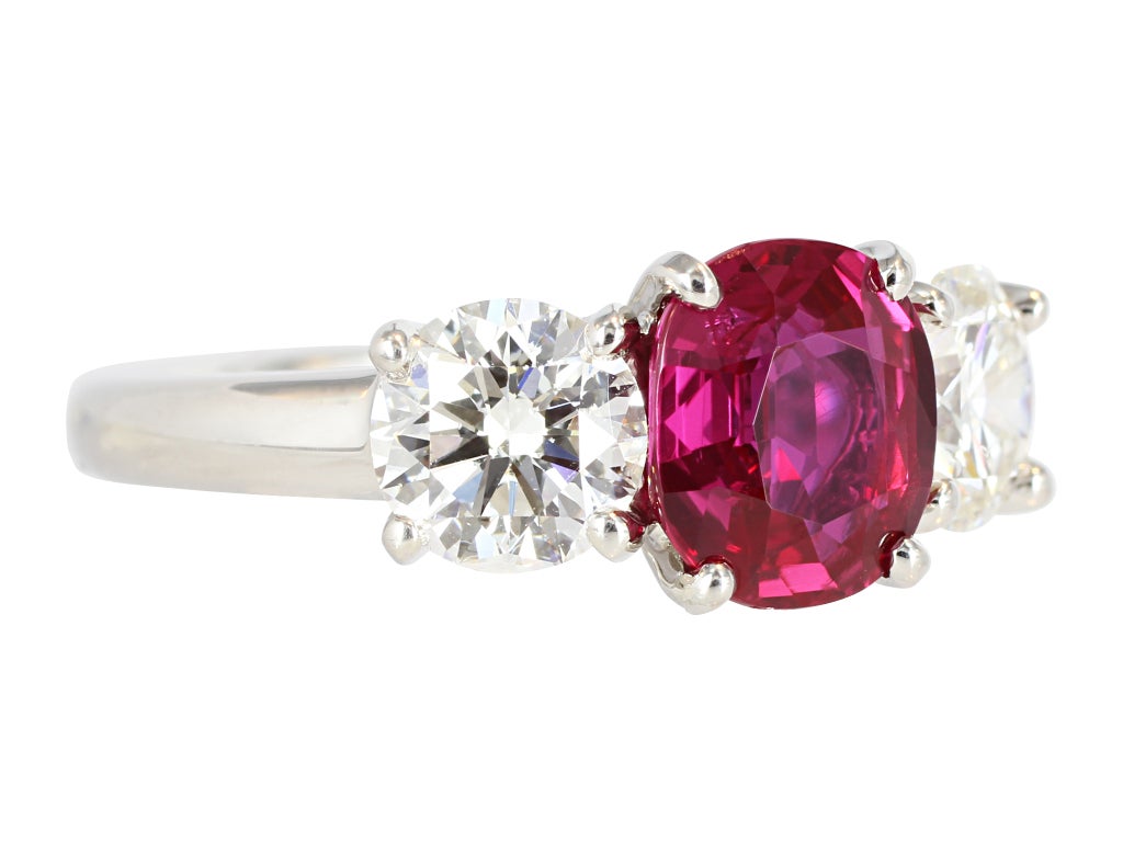 Platinum custom made 3 stone ring consisting of 1 cushion cut Burma ruby weighing 1.84 carats, measuring 7.75 x 6.70 x 3.82mm with AGL certificate CS 53941 stating No Heat, the center stone is flanked by 2 round brilliant cut diamonds having a total