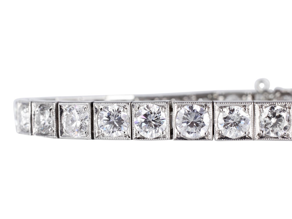 Estate platinum block style tennis bracelet consisting of 32 bead set round brilliant cut diamonds having an approximate total weight of 10.00 carats and accented with millgrain edges.