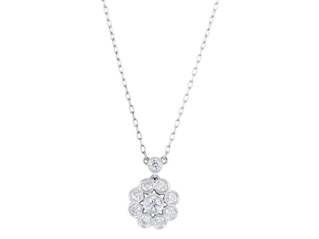 Platinum vintage style cluster pendant consisting of approximately .80 carats of round brilliant cut diamonds.
