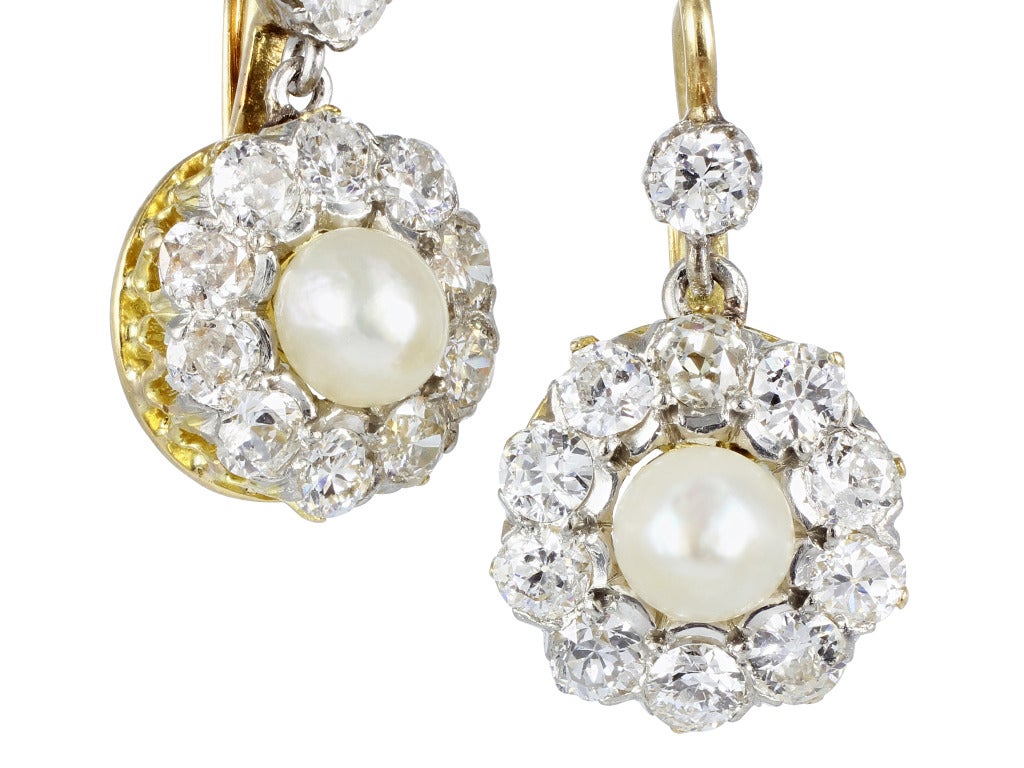 Victorian 14 karat yellow gold antique drop earrings consisting of approximately 1.00 carat total weight of Old European cut diamonds with pearl accents.