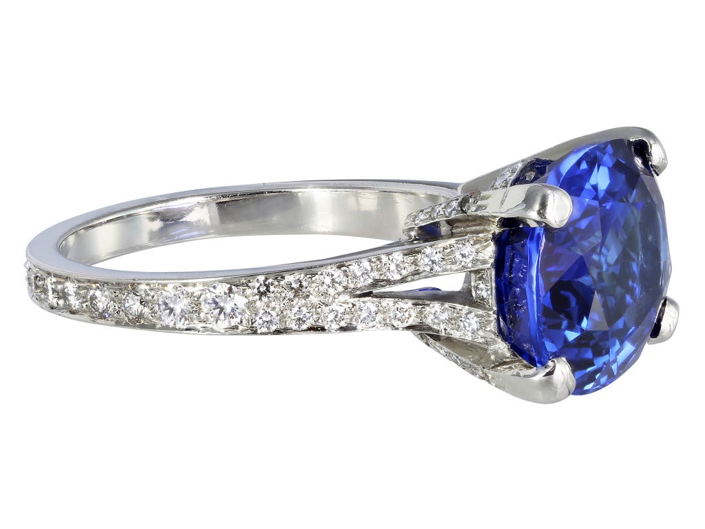 Platinum solitaire ring consisting of 1 horizontal set oval shaped blue sapphire weighing 8.25 carats, measuring 13.85 x 10.34 x 6.33mm with AGL certificate CS 57047 stating origin as Sri Lanka, the center stone is set with full cut diamonds going