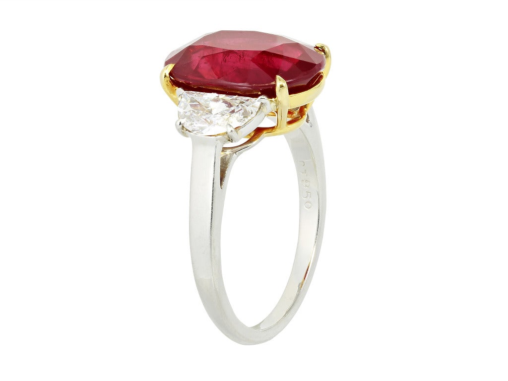 Platinum and 18 karat yellow gold custom made 3 stone ring consisting of 1 oval shape ruby weighing 7.04 carats, measuring 13.23 x 9.87 x 5.79mm, with AGL certificate CS 46330, the center stone is flanked by 2 half moon diamonds weighing