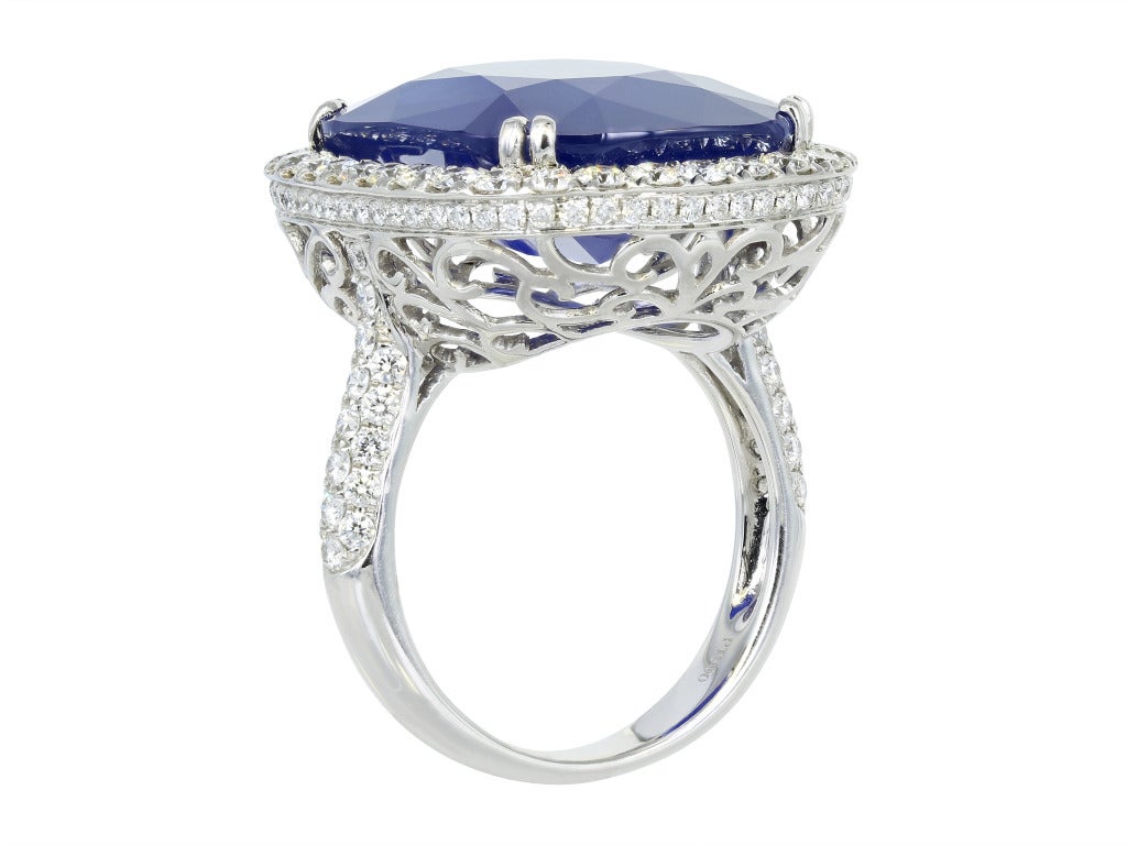 Platinum custom made solitaire ring consisting of 1 cushion cut Ceylon Cornflower blue sapphire weighing 21.19 carats with GRD report and surrounded by 1 row of full cut diamonds and with full cut diamonds going down the shoulders and a custom