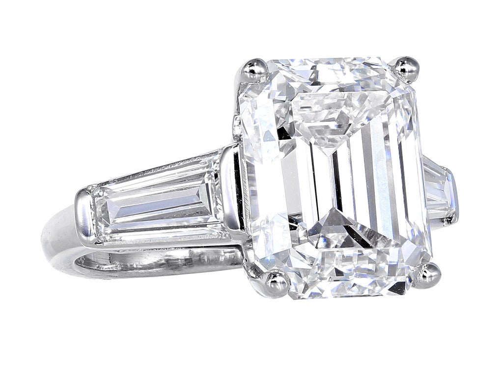 Platinum custom made solitaire ring consisting of 1 emerald cut diamond weighing 7.54 carats having a color and clarity of F/IF. measuring 12.37 x 9.85 x 7.12mm with GIA certificate #5141092, the center stone is flanked by 2 tapered baguettes having