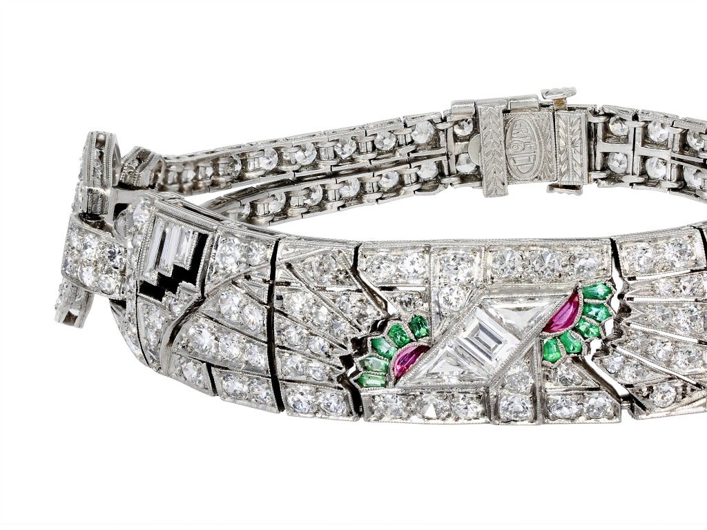 Platinum Art Deco Egyptian Revival
multi-gem flexible bracelet consisting of Old
European cut diamonds, custom cut
emeralds, rubies and onyx. Circa 1925