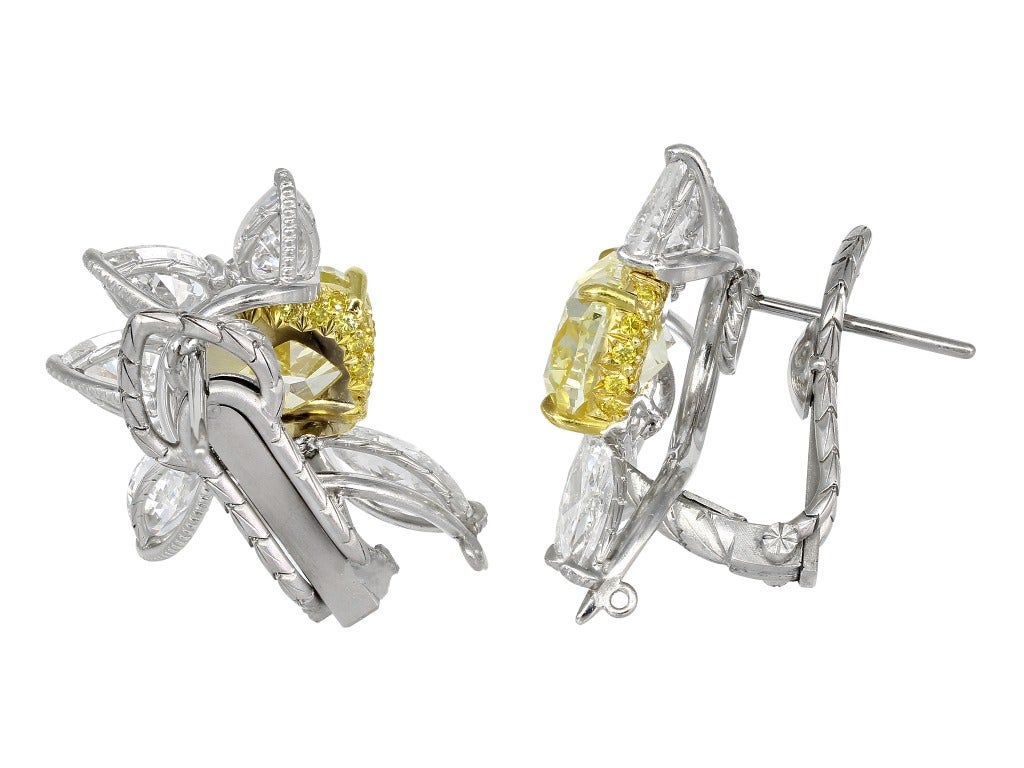 Platinum & 18 karat yellow gold cluster earrings consisting of 1 cushion cut canary diamond weighing 2.05 carats having a color and clarity of FY/VS2 with GIA certificate #5121382767 and 1 cushion cut canary diamond weighing 2.03 carats with GIA