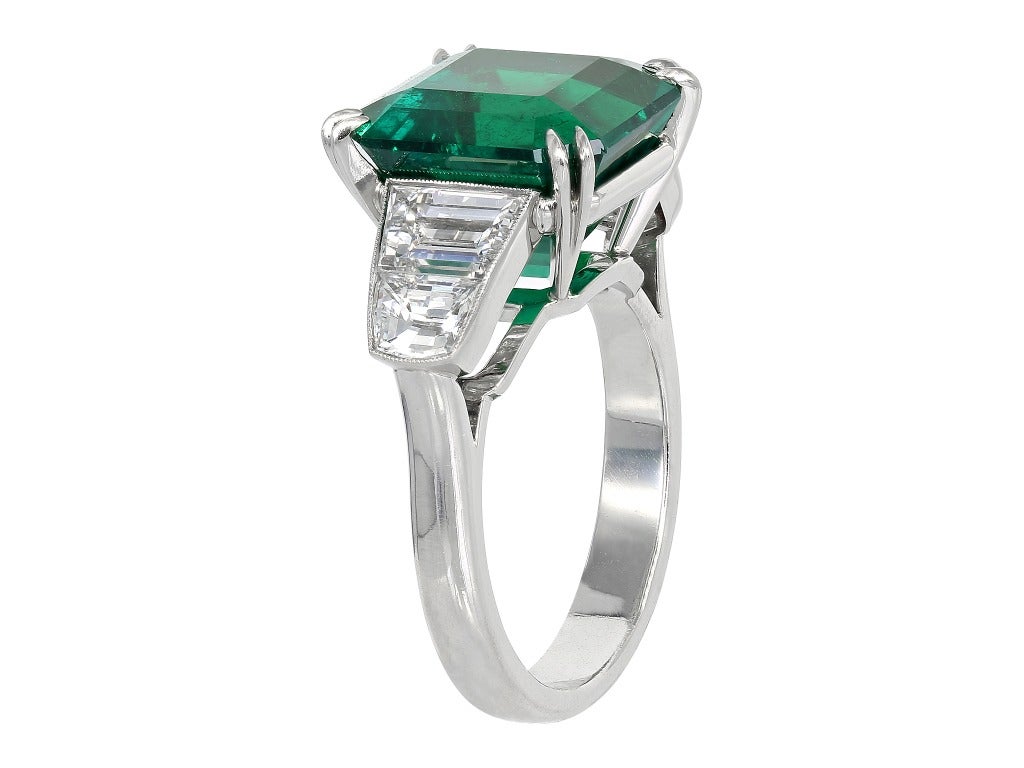 Platinum custom made 3 stone ring consisting of 1 square emerald cut Colombian emerald weighing 7.28 carats with GIA certificate #5111867580, the center stone is flanked by 2 step but half moons weighing .80 carats and 2 step cut trapezoid shaped