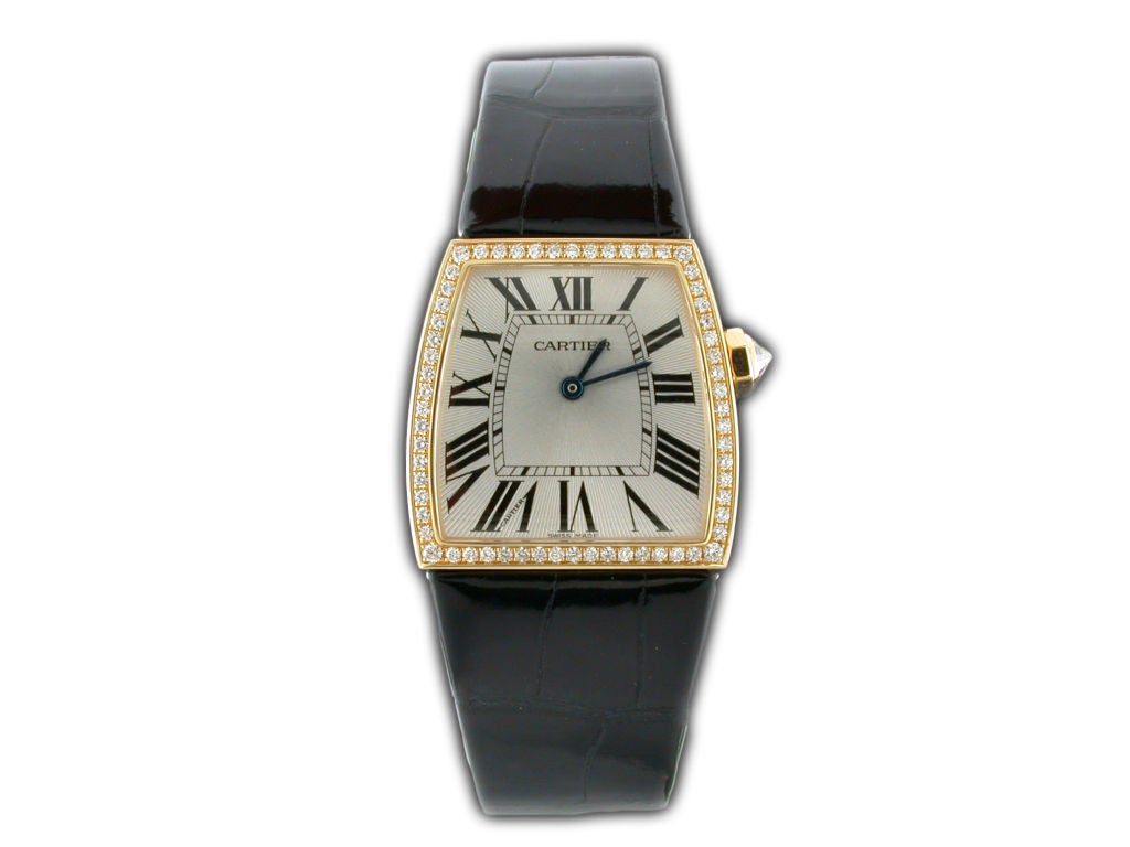 This stylish and elegant Cartier La Dona watch is the perfect addition to a woman's fine jewelry collection. The watch features an 18 karat yellow gold case surrounded by a row of impeccably set diamonds with a beautiful Silver Guilloche dial with