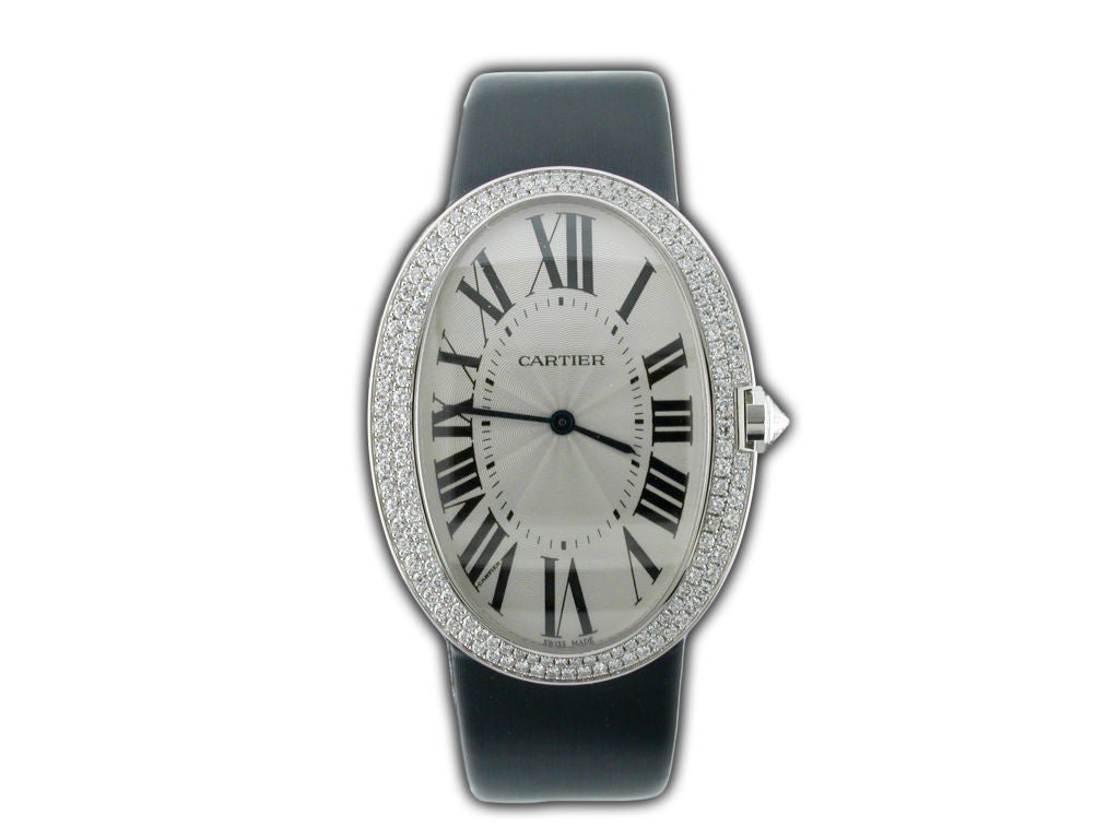 This elegant and chic Cartier Baignoire is as much of a statement as a watch as it is as a fine piece of jewelry.  The watch features a large white gold case surrounded by rows of perfectly set pave diamonds and a diamond crown. The dial is a
