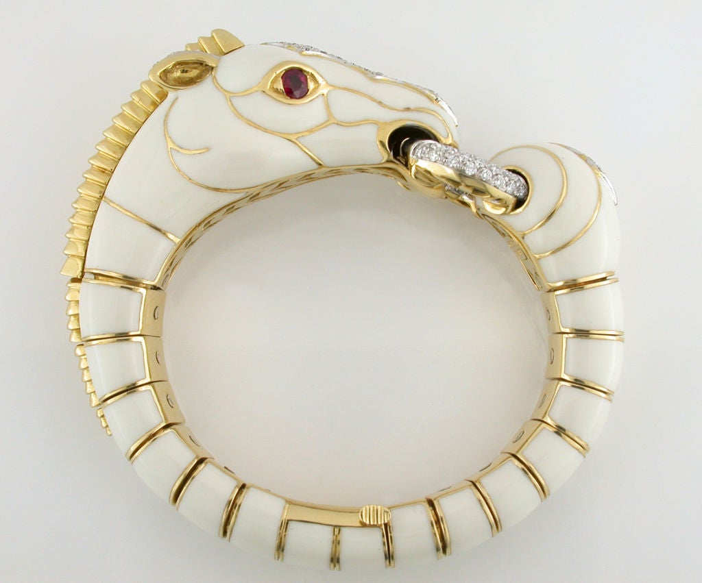 The perfect bracelet for a horse enthusiast or David Webb collector. This unique bracelet is in excellent near perfect condition. The piece is designed in 18 karat yellow gold, platinum and white enamel. Two vivid red full cut rubies are used for