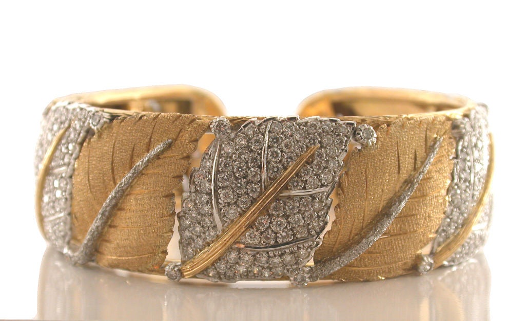 Exquisite Italian 18kt white and yellow gold leaf designed hinged cuff bracelet by M. Buccellati. This unique piece is crafted with three leaves pave set with full cut round diamonds having a total approximate weight of  3.75 carats. The diamond