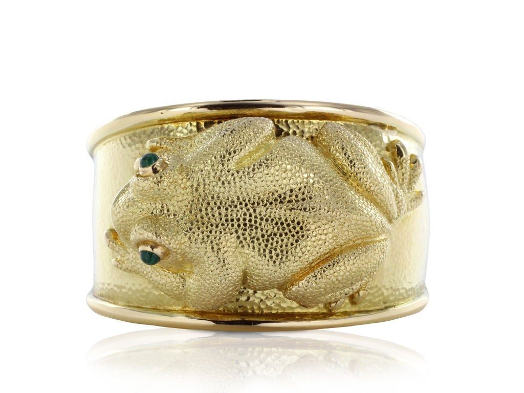 This vintage, 18 karat yellow gold David Webb cuff bracelet is the perfect piece for a collector or frog enthusiast. The bracelet is extremely well crafted in solid gold. The intricate and charming frog has two emerald cabochon eyes. The back of the