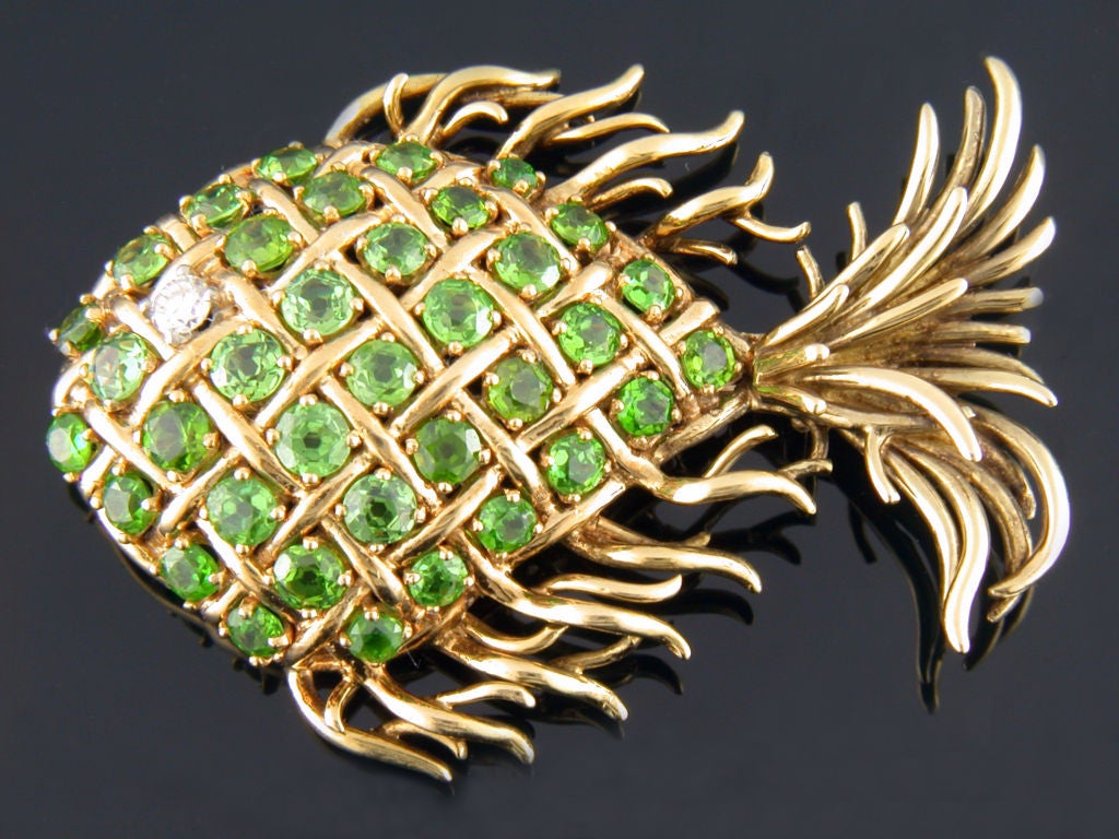 Unique 18 karat yellow gold Tiffany & Co fish pin. The body consists of 36 vibrant old European cut dematoid garnets having an approximate total weight of 5.50 carats and 1 full cut diamond eye having a weight of approximately .12 carats.