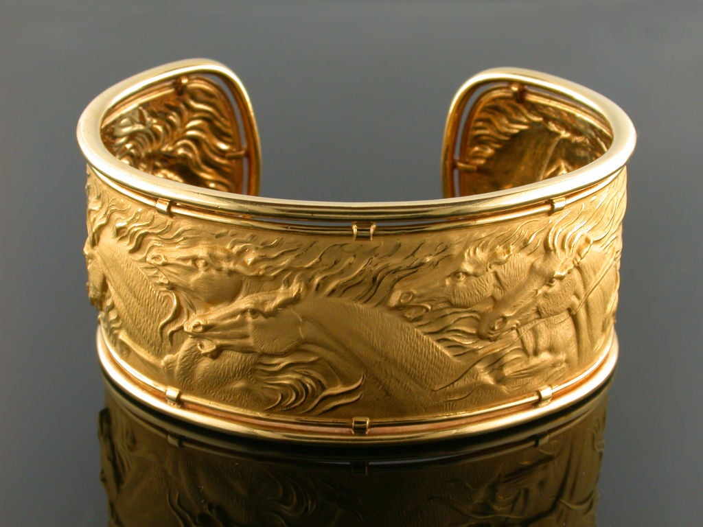 Exquisite 18kt yellow gold cuff bracelet, depicting an intricate scene of galloping horses. Crafted by the spanish designers Carrera Y Carrera, this particular design exemplifies the elegance and boldness associated with their work. This style has