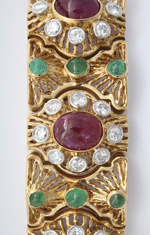 Van Cleef bracelet, 18KT gold in detailed openwork of spiraled spoke elements set with cabachon rubies, emeralds and diamonds. Van Cleef mark