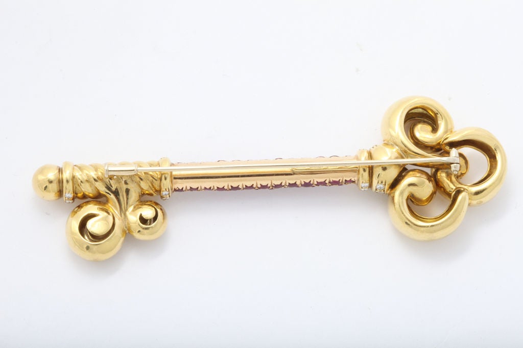 A strikingly large beautifully crafted 18K gold brooch shaped as a fancy  antique key generously set with rubies and diamonds. Wear on a jacket, a headband, or evening bag. Measuring 4 inches long. Italian maker and gold marks. Weighing 48.3 grams.