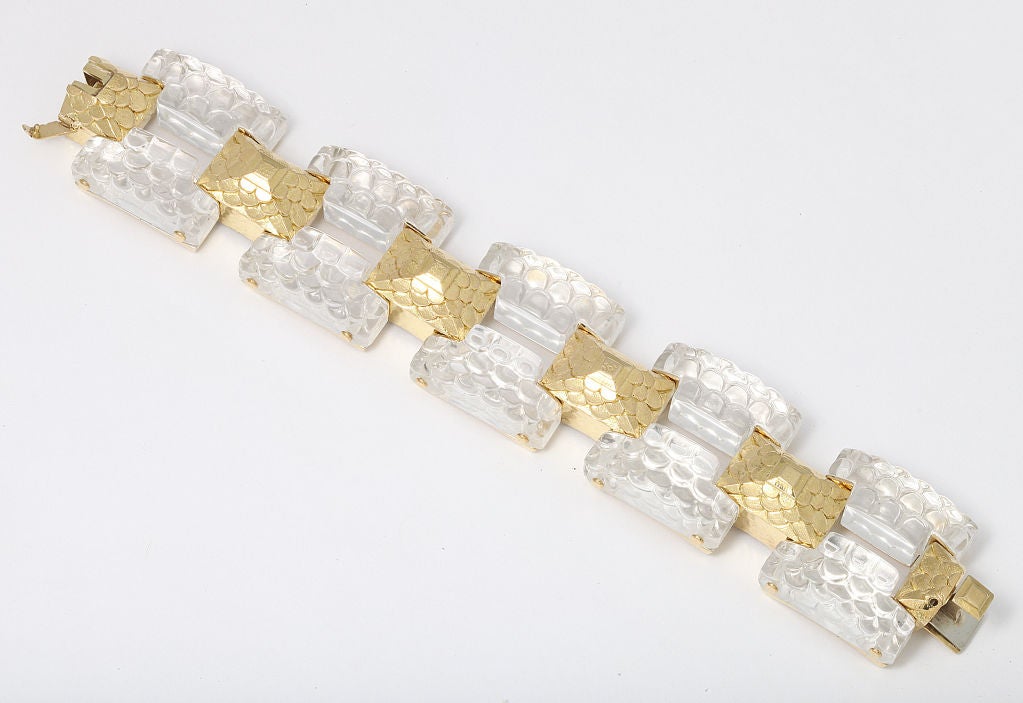 Wide, thick and impressive David Webb bracelet in 18K gold with carved rock crystal. The five central links formed as rectangular gold pyramids chased with a fish scale or tiled effect, connecting five gold beds holding ten individual carved crystal