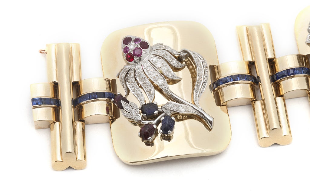 Highly unusual 14K gold retro bracelet featuring 3-dimensional, diamond-set flowers highlighted with carved rubies and sapphires, mounted on large plaques held  by wide links bisected with a channel of sapphires. Unmarked.