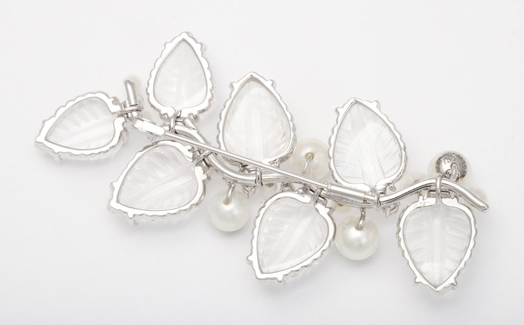 A shimmering Seamann Schepps 18K gold branch of engraved cabochon rock crystal leaves, mounted to move independently among pearl and diamond tipped stems, and larger pearl berries with diamond centers.  From original 1940s design called 