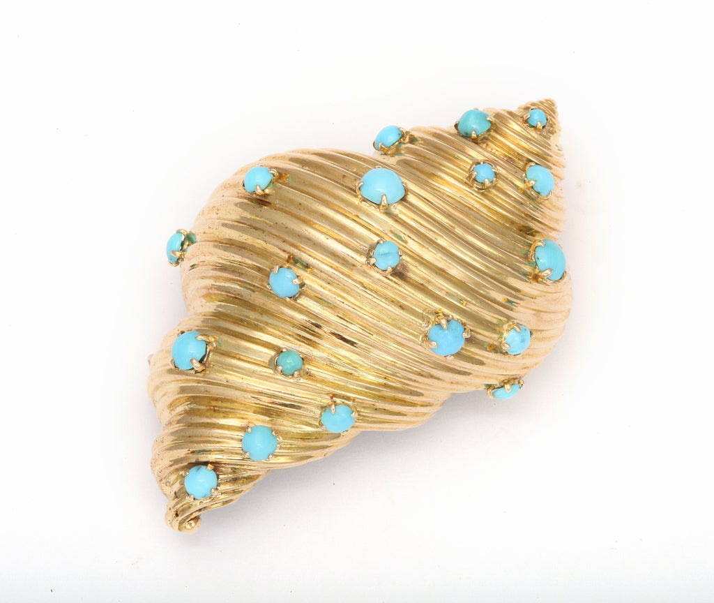 A three dimensional, spiraling shell of glittering 18K gold, studded with cabochons of Persian turquoise. 1 1/2 in x 2 1/4 in. French gold marks and Tiffany EC France. 21.7 pennyweights.