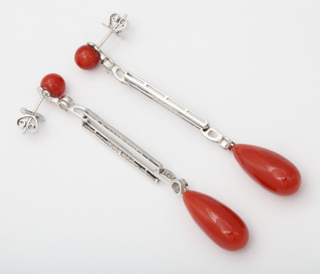 Platinum earrings of slendor Art Deco design from Sophia D. (jewelry maker for Fred Leighton, Cartier and Bulgari) comprised of rich red coral, diamonds and deep blue sapphires. 2 3/4 inches long. Marks: Platinum, Sophia D., control numbers.