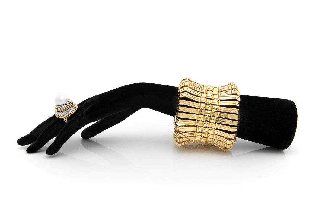 We are pleased to offer a glamorous one-of-a-kind three dimensional cuff bracelet made to order in 1973 by Cartier New York composed of eye catching flexible bridge-like sections designed with a central basket weave effect and widening to a curled
