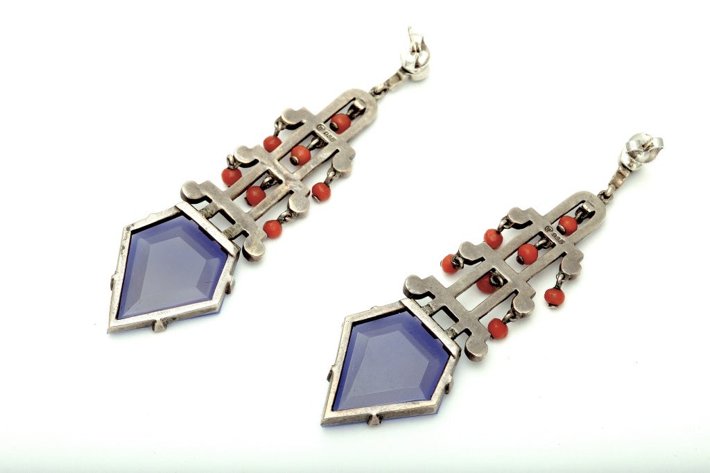 Spectacular Asian inspired Art Deco earrings by Theodor Fahrner, c.1926, in sterling silver set with large faceted lavendar-blue chalcedony stones, highlighted with marcasites, hung with coral beads, suspended from onyx cabs on the ear. Original