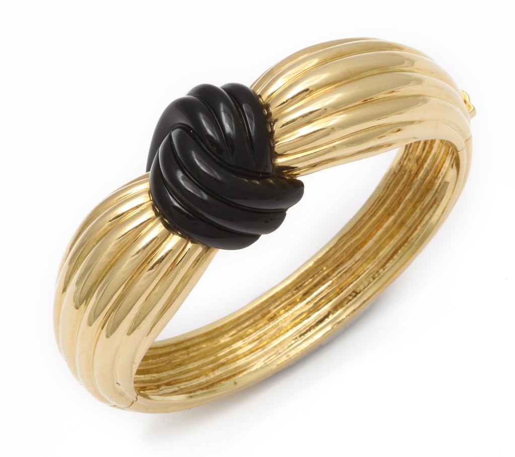Sophisticated and beautifully crafted bracelet by New York firm Turi, as an 18K gold swath of fabric gathered to a knot of carved black jade, with matching knot earclips. Marked: Turi, 18K. Bracelet fits 6 1/4 inch wrist. Sold only as a set.