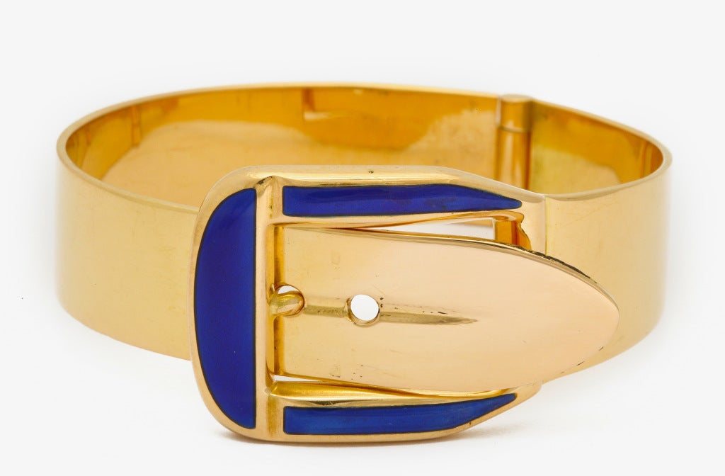 1970's Sleek, modern, uni-sex Gucci buckle bracelet in rich 18K gold, with royal blue enamel detail. Marked Gucci Italy, 750. Easy on and off - tongue slides into spring action buckle. Two hole adjustment from wrist size 7 in. to 7 1/4 in. Widest 1
