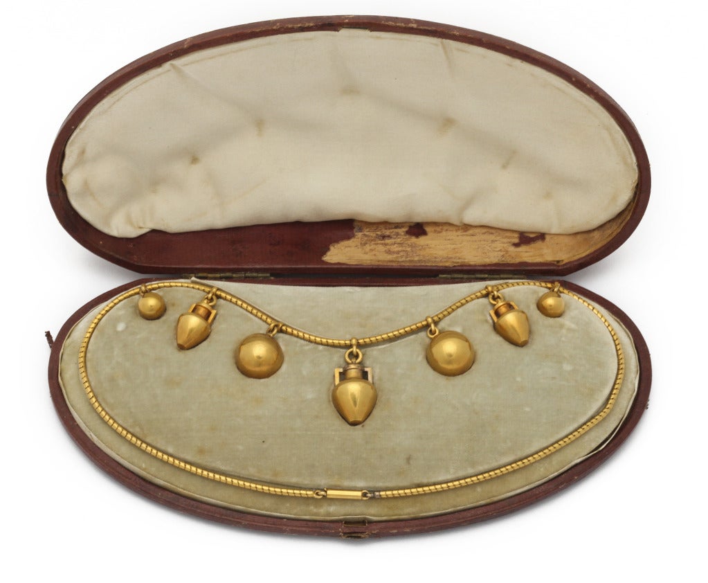 Simple elegance in this 1850s Etruscan revival necklace of 15K gold chain, hung with three classic 2-handled amphoras (the larger holds a braid of hair under glass), complimented by four simple gold balls. 16 inches. Kept in beautiful condition in